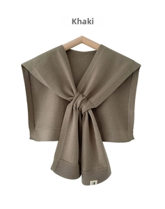 Detail of khaki knitted shawl showing ribbed edge texture and soft fabric finish