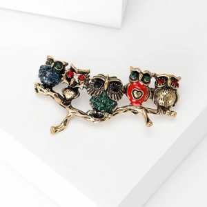 Detailed close-up of colorful owl brooch with enamel inlay and sparkling rhinestones