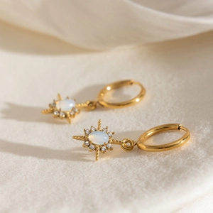 Macro detail of gold starburst earrings with opal center and shimmering micro-set rhinestones