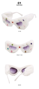 Dettaglio occhiali da sole in pelliccia bianca con lenti viola sfumate e strass colorati