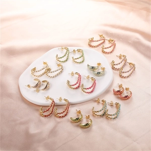 Colorful enamel hoop earrings in gold finish set on champagne silk and display tray