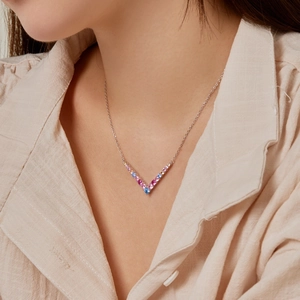 Model wearing a V-shaped S925 silver necklace with gradient pink and blue zircons