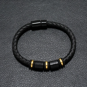 Detail of multi-layer black braided leather bracelet with gold beads and magnetic clasp