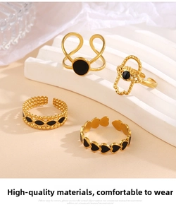 Detail view of 4-piece gold ring set with black enamel evil eye and heart patterns