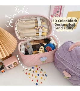 Detail of quilted corduroy makeup bags with tulip zipper pull and brush slots