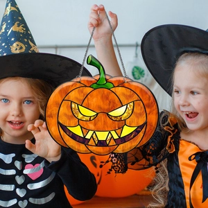 Close-up of Halloween pumpkin lantern ornament with iron chain held by children