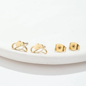 Pair of gold stainless steel cowboy hat stud earrings on a clean white circular stand