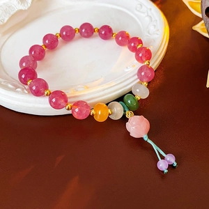 Detail of pink lotus flower bracelet with colorful beads on vintage white carved plate