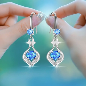 Elegant drop earrings featuring round blue crystals in a silver-toned flame setting