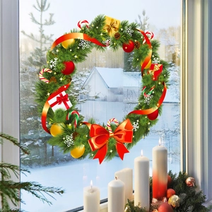 Couronne de Noël en PVC avec aiguilles de pin et baies rouges sur une fenêtre enneigée