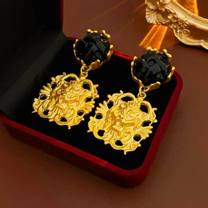 Close-up of vintage lion head earrings with black gemstone in a red velvet jewelry box