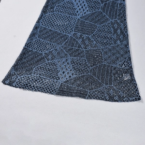 Dettaglio ravvicinato della trama in pizzo traforato geometrico blu e nero