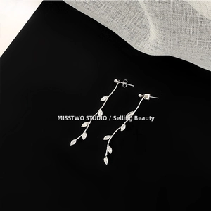 Macro detail of silver leaf tassel earrings with sparkling marquise zircon inlays