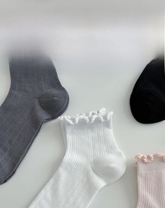 Detail of ribbed knit cotton socks with cute scalloped edges in various pastel colors
