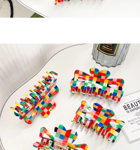 Detail of four colorful checkerboard hair claws with high-gloss finish and metal springs