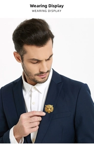 Detailed close-up of a golden tiger head brooch worn on a navy blue business suit lapel