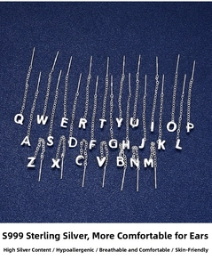 Flat lay of S999 sterling silver letter tassels on dark blue textured background