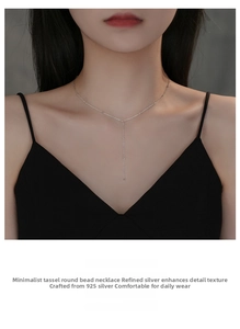 Detailed view of S925 sterling silver tassel necklace with tiny beads on a female model