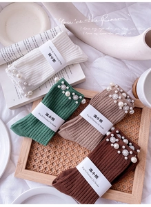 Close-up of ribbed knit socks with elegant pearl and rhinestone floral decorations