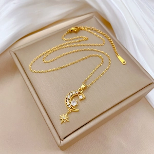 Collier lune et étoile doré avec zircons blancs sur fond de soie blanche