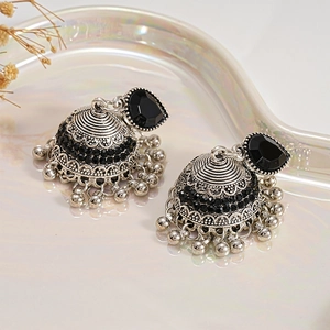 Macro detail of vintage Jhumka earrings with black rhinestones and silver filigree