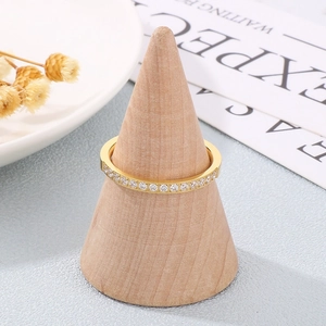 Detail of a gold row diamond ring with clear zircons on a wooden cone display stand