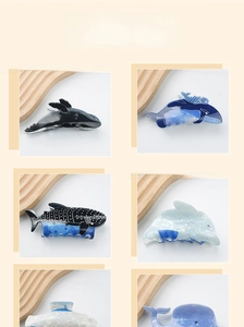 Detail showing acetate hair claws in whale and dolphin shapes with blue patterns