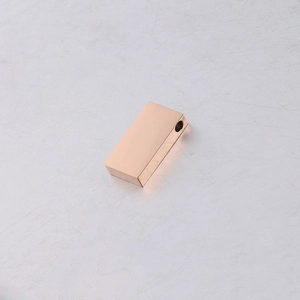 Macro detail of rose gold rectangular stainless steel charm with smooth mirror finish
