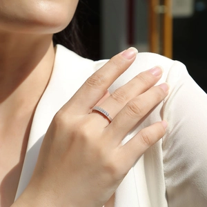 Detail of elegant silver ring with double row micro-pave moissanite on a model's finger