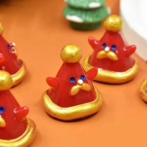 Vue détaillée de figurines bonnet de Noël en résine avec bordure dorée et détails festifs