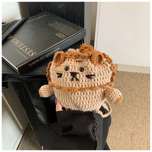 Detailed crochet texture of a handmade lion drawstring bag with beige yarn and brown mane