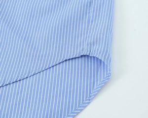 Detail of blue and white striped shirt showing the curved hem and high-quality stitching