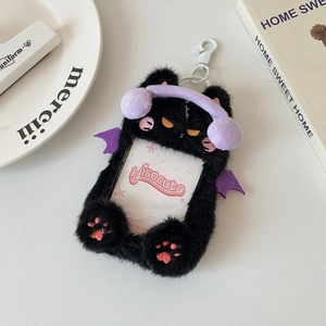 Close-up of a plush black cat photo card holder with purple headphones and devil wings