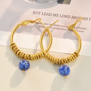 Detailed close-up of 14k gold U-shaped earring featuring a natural blue stone bead pendant