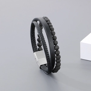 Detail view of men's multilayered black leather bracelet with volcanic stone beads