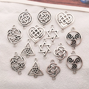 Detailed flat lay of silver Celtic knot and heart charms for DIY jewelry making