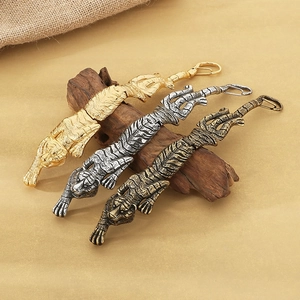 Three vintage tiger keychains in gold, silver and bronze on wood display