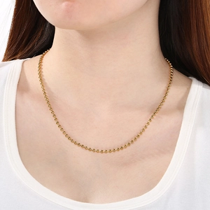 Collier minimaliste en perles d'acier inoxydable plaqué or 18K porté par un modèle