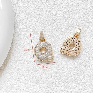 Macro shot of gold letter Q pendant with cubic zirconia and 30mm x 18mm dimensions