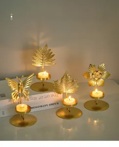 Detailed close-up of golden iron candle holders with butterfly and leaf designs
