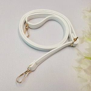 Détail de la bandoulière réglable en cuir PU blanc à motif litchi et boucles dorées