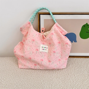 Detailed quilted texture of pink floral bunny tote with light green woven handles