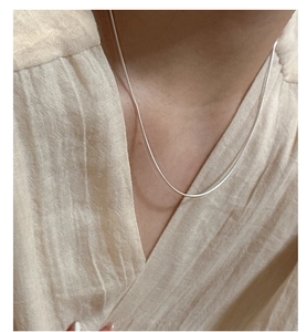 Primo piano della collana minimalista in argento S925 a maglia serpente sul collo della modella