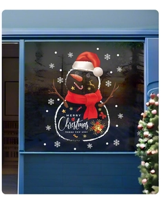 Dettaglio di adesivo natalizio per finestre con pupazzo di neve su vetro e testo Buon Natale