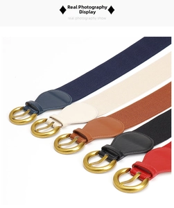 Detail of five elastic waist belts in navy, cream, tan, black, and red with gold buckles