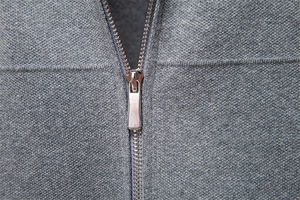 Detail of silver metal zipper on premium grey knit cardigan for men with fabric texture