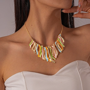Close-up of a wavy geometric necklace with colorful enamel inlay and golden tassels