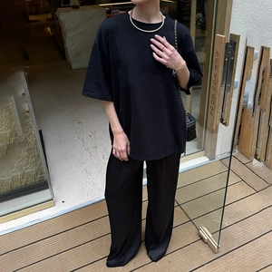 Detailansicht der schwarzen Schlaghose mit hoher Taille und schicker Kettentasche