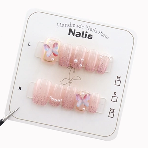 Pink gradient press-on nails with 3D butterflies, pearls and glitter on a white card