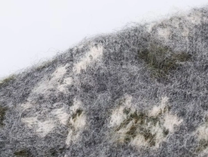 Macro shot of grey and moss green jacquard knit fabric with soft marble texture and long fiber